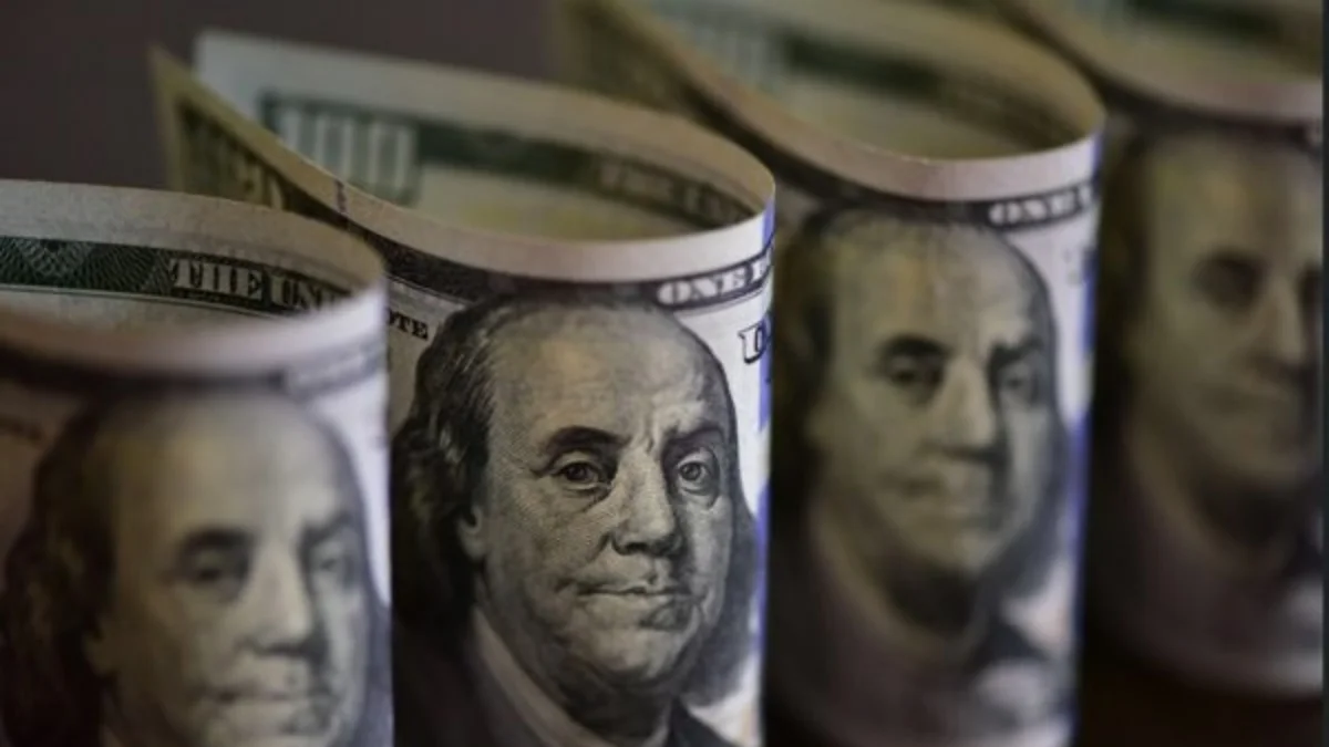 Dólar abre em ligeira queda à espera de definição da Selic