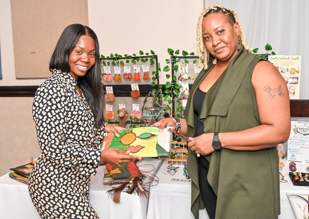 Shanna Campbell (right), chief executive officer and designer of Vintage Chic, shows Shanique Gordon, JMEA marketing, public relations and events manager, one of the brand’s locally made wristlets.