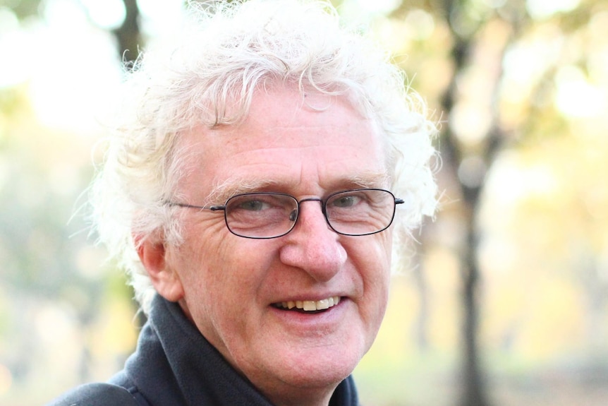 Terry Denton smiles at the camera wearing glasses and smiling