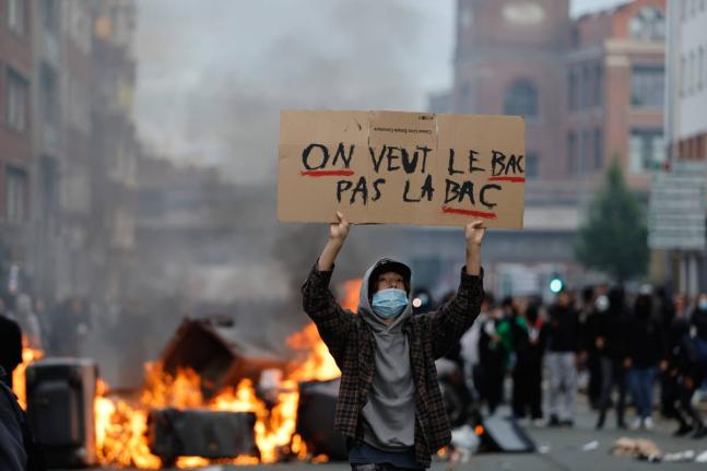 A student holds a board reading, ‘we want the BAC (High School Diploma) Not the BAC (Anti-criminality units)’ during a protest to demand more resources at school, in Lille, France, Thursday.